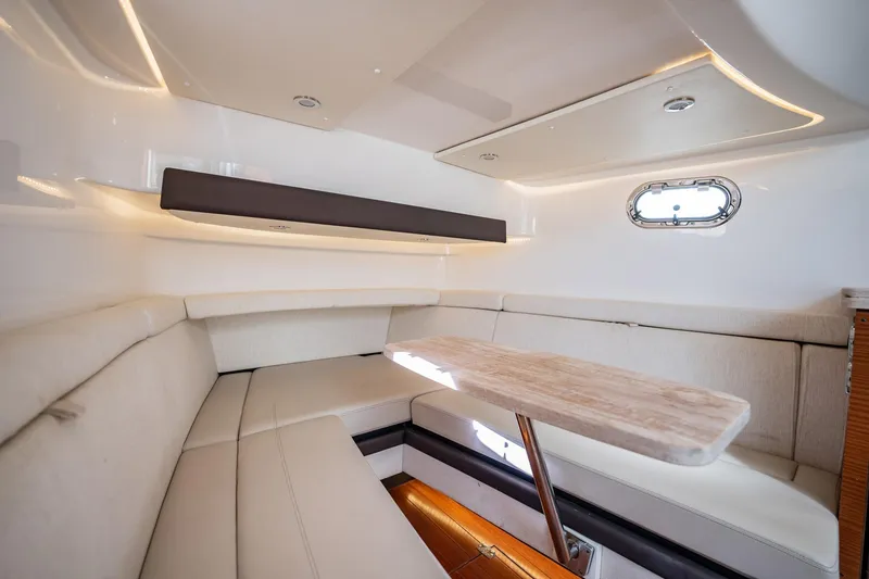 Slide: The Image of 2020 Pursuit S 408 Sport cabin interior with beige seating and wooden table. - 15