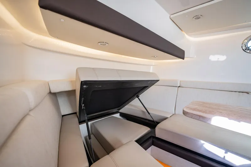 Slide: The Image of 2020 Pursuit S 408 Sport boat interior with beige seating and storage compartment. - 16