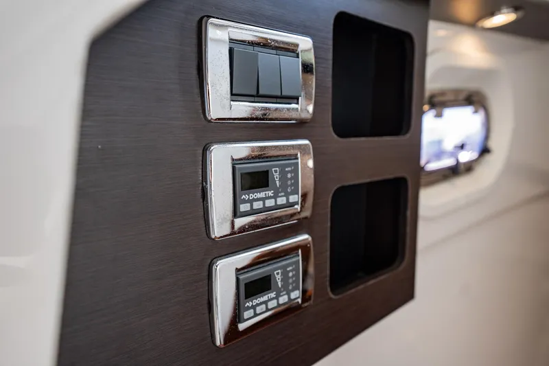 Slide: The Image of Control panel inside 2020 Pursuit S 408 Sport boat, featuring switches and digital displays. - 20