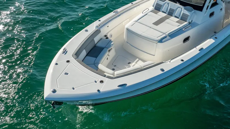 Slide: The Image of 2020 Pursuit S 408 Sport boat on clear green water, showcasing sleek design and spacious deck. - 22