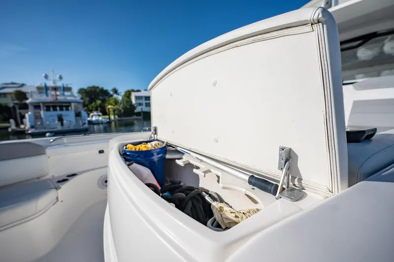 Slide: The Image of Storage compartment on a 2020 Pursuit S 408 Sport boat, open with gear inside. - 25