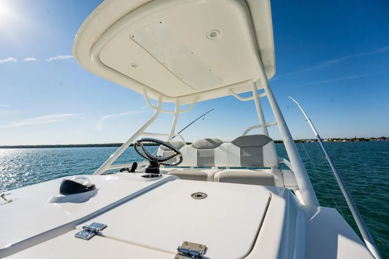 Slide: The Image of 2020 Pursuit S 408 Sport boat on open water, clear sky, fishing rods visible. - 40