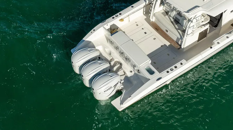Slide: The Image of 2020 Pursuit S 408 Sport boat with triple outboard engines on clear water. - 48