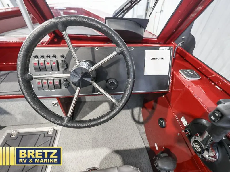 Slide: The Image of Steering wheel and dashboard of 2025 Evolution 221 boat, featuring Mercury controls. - 12