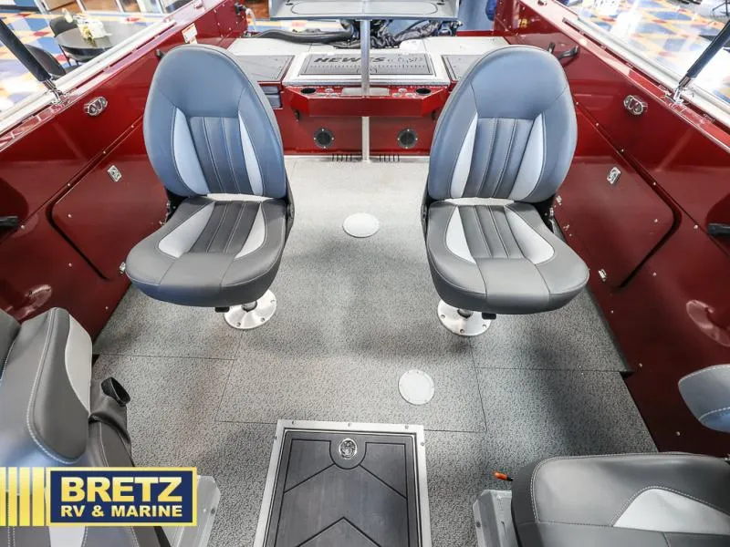 Slide: The Image of Interior of 2025 Evolution 221 boat with two gray seats, red walls, and Bretz RV & Marine logo. - 16