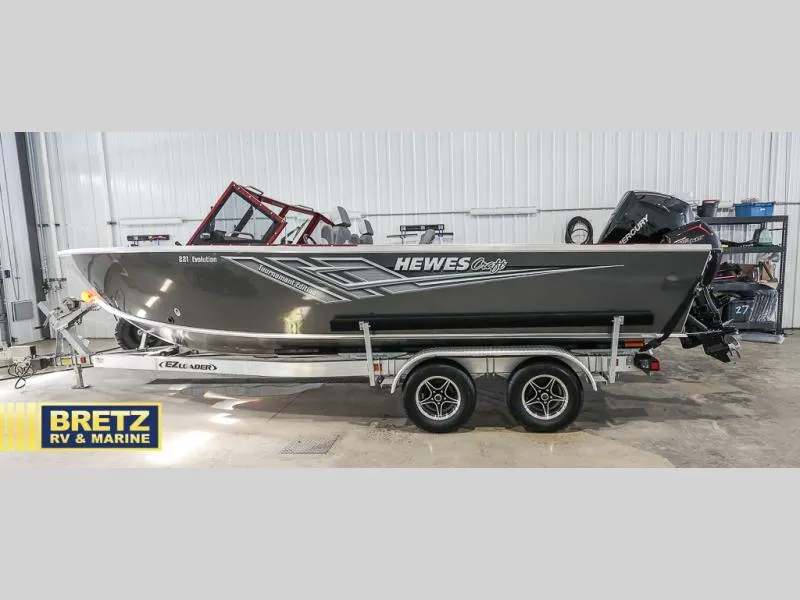Slide: The Image of 2025 Evolution 221 boat on trailer at Bretz RV & Marine showroom. - 7