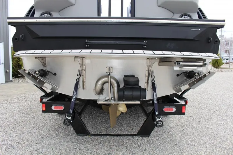 Slide: The Image of 2025 Montara Surf Boss CW 25' boat rear view, showcasing propeller and engine details. - 10