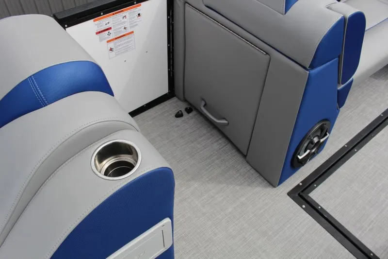 Slide: The Image of 2025 Montara Surf Boss CW 25' interior with blue and gray seating, cup holder, and speaker. - 7