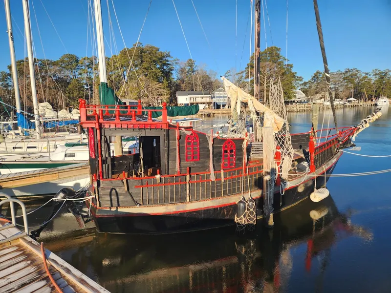 The Image of 1982 Watkins 27 Pirate Ship docked in a serene marina setting. - 0