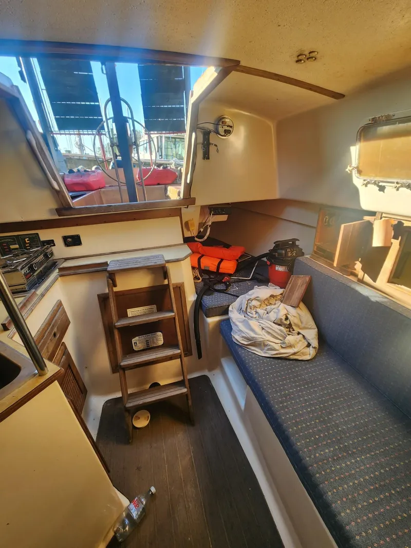 Slide: The Image of Interior of 1982 Watkins 27 Pirate Ship, featuring cozy seating and nautical equipment. - 13