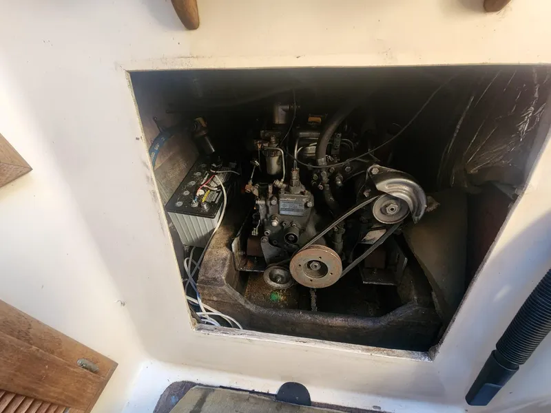 Slide: The Image of Engine compartment of 1982 Watkins 27 Pirate Ship, showing mechanical components and battery. - 18