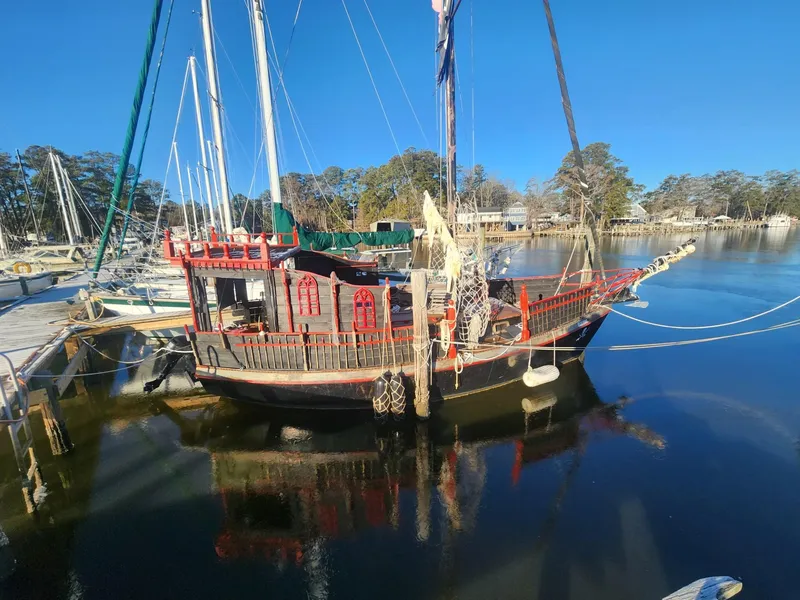 Slide: The Image of 1982 Watkins 27 Pirate Ship docked on a calm lake. - 2