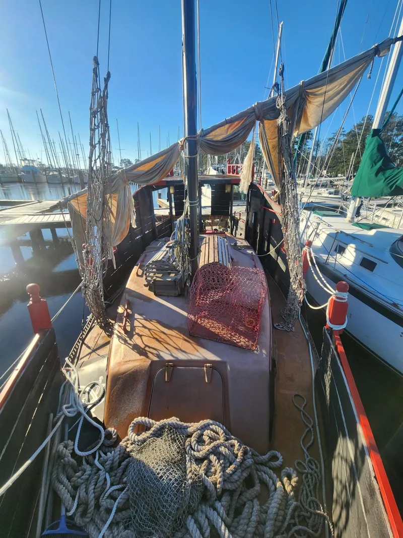 Slide: The Image of Interior of 1982 Watkins 27 Pirate Ship, featuring cozy seating and compact kitchen area. - 23