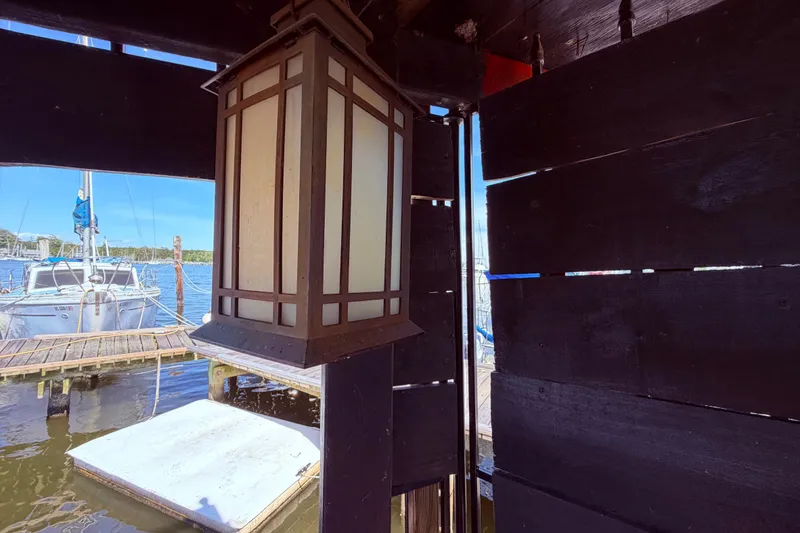 Slide: The Image of Lantern inside wooden structure with Watkins 27 Pirate Ship docked outside, 1982 model. - 46