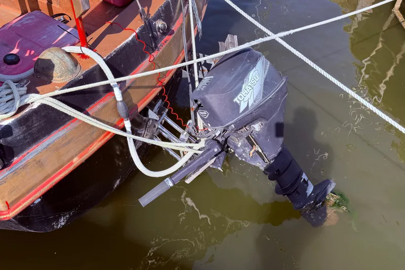 Slide: The Image of Outboard motor on 1982 Watkins 27 Pirate Ship, docked in calm water. - 48