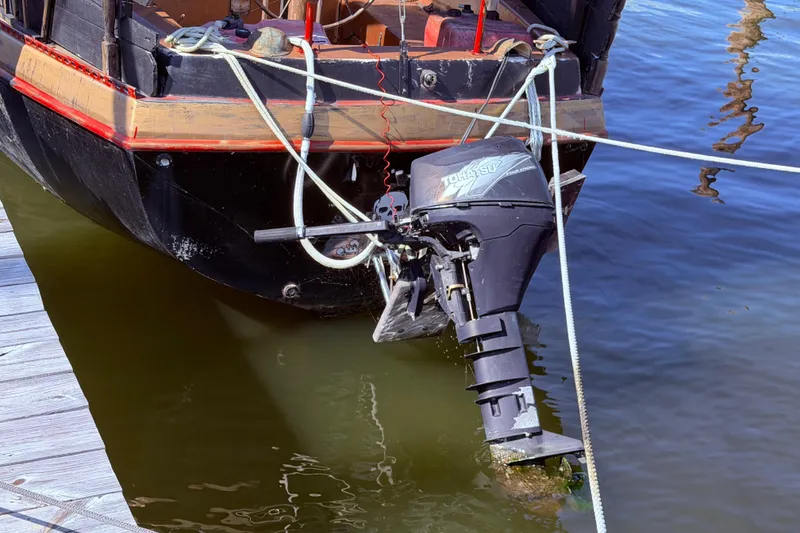 Slide: The Image of 1982 Watkins 27 Pirate Ship with outboard motor docked at marina. - 49