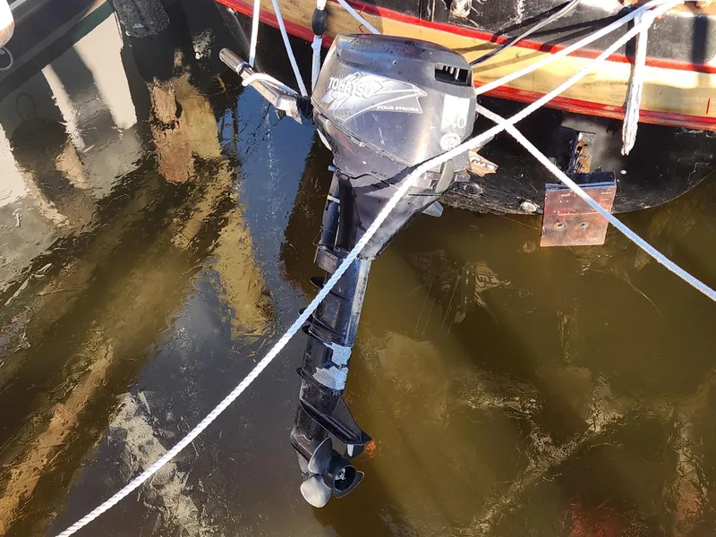 Slide: The Image of Outboard motor on 1982 Watkins 27 Pirate Ship, docked in calm water. - 7