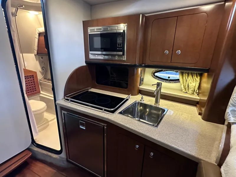 Slide: The Image of 2020 Crownline 330 SY yacht interior with kitchenette and bathroom. - 23