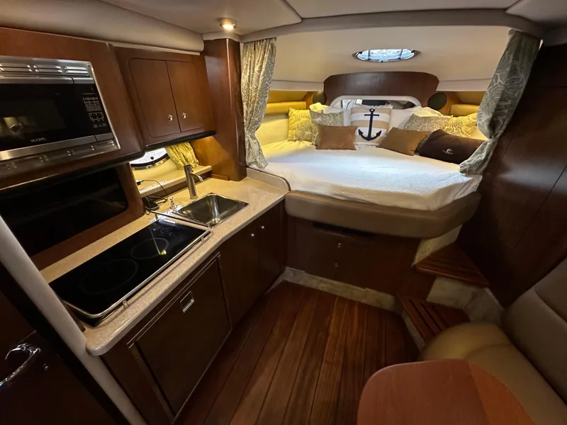 Slide: The Image of Luxurious 2020 Crownline 330 SY yacht interior with cozy bed and modern kitchen amenities. - 24