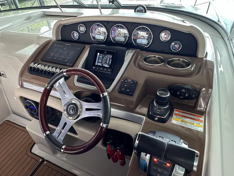 Slide: The Image of Dashboard of 2020 Crownline 330 SY boat with steering wheel and control panels. - 27