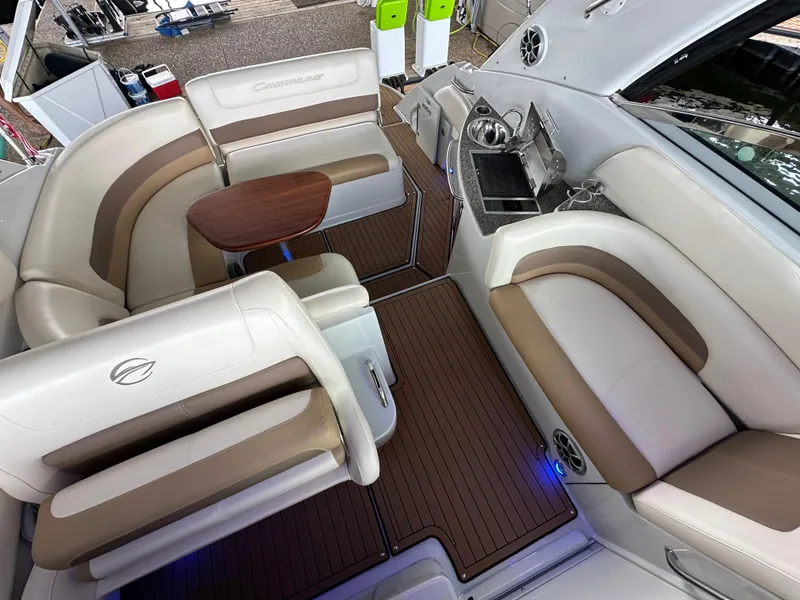 Slide: The Image of 2020 Crownline 330 SY boat interior with plush seating and wooden table. - 29