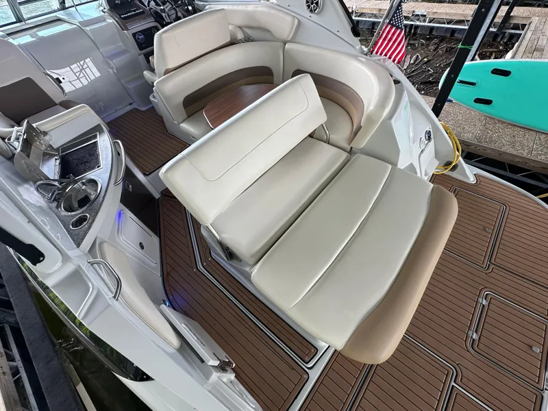 Slide: The Image of 2020 Crownline 330 SY boat interior with plush seating and wood-style flooring. - 32