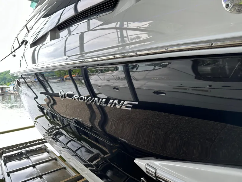 Slide: The Image of 2020 Crownline 330 SY boat docked, showcasing sleek design and branding. - 8