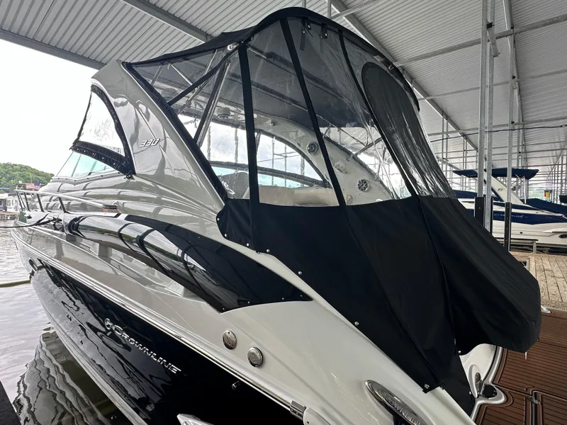 Slide: The Image of 2020 Crownline 330 SY boat with black canopy in marina. - 9