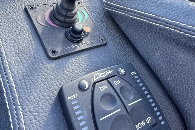 Slide: The Image of Close-up of 2018 Regal 29 OBX boat controls, featuring thruster and trim tab buttons. - 24