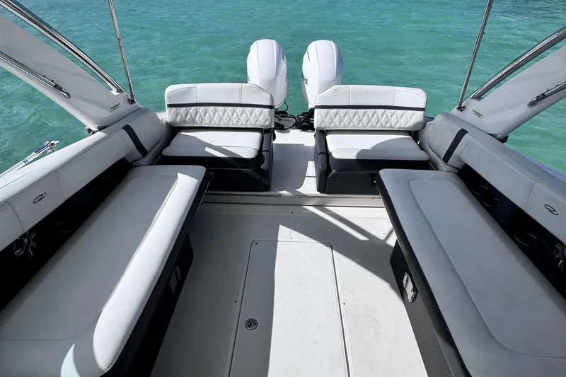 Slide: The Image of 2018 Regal 29 OBX boat interior with spacious seating and twin engines on turquoise water. - 34