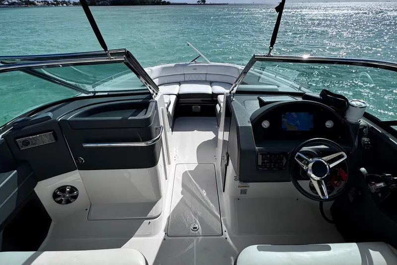 Slide: The Image of 2018 Regal 29 OBX boat interior with steering wheel, dashboard, and open water view. - 40