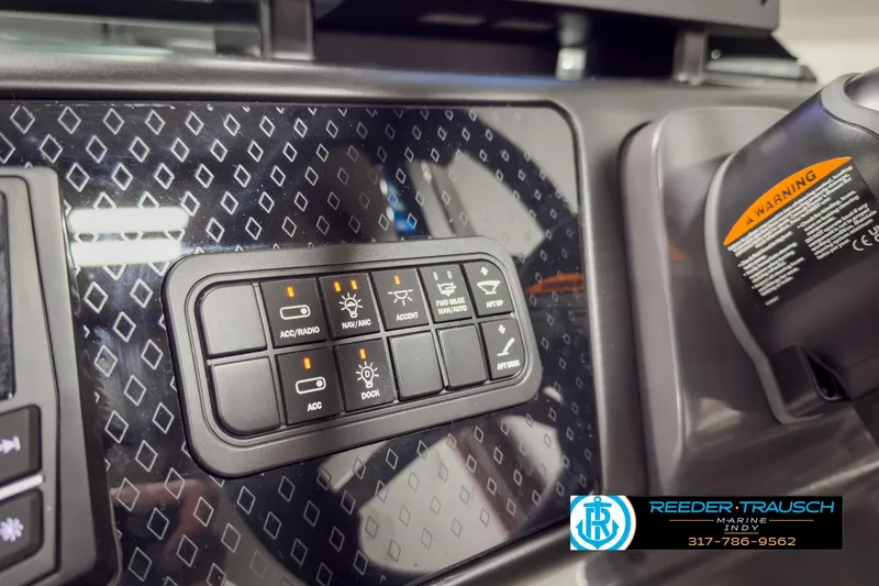 Slide: The Image of Control panel of 2025 Bennington 22 MSB boat with various switches and warning label. - 33