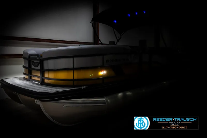 Slide: The Image of 2025 Bennington 22 MSB pontoon boat in dimly lit showroom. - 4