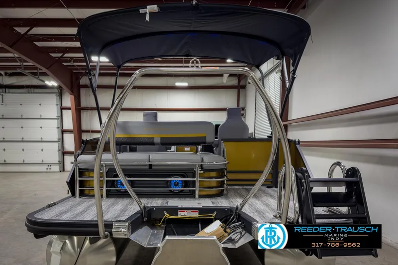 Slide: The Image of 2025 Bennington 22 MSB pontoon boat in a warehouse, featuring a sleek design and modern amenities. - 7