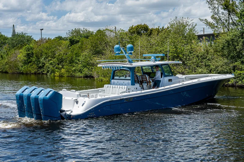 Slide: The Image of 2023 HCB 53 Sueños boat cruising on a river with lush greenery. - 1