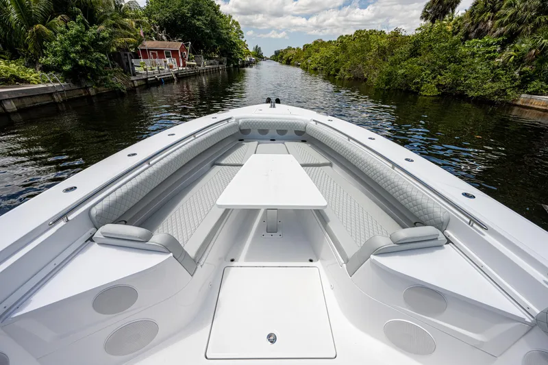 Slide: The Image of 2023 HCB 53 Sueños boat with spacious seating and table on a scenic waterway. - 24
