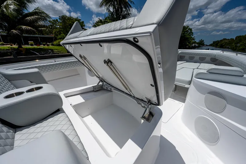 Slide: The Image of 2023 HCB 53 Sueños boat interior with open storage compartment, luxurious seating, and cup holders. - 27