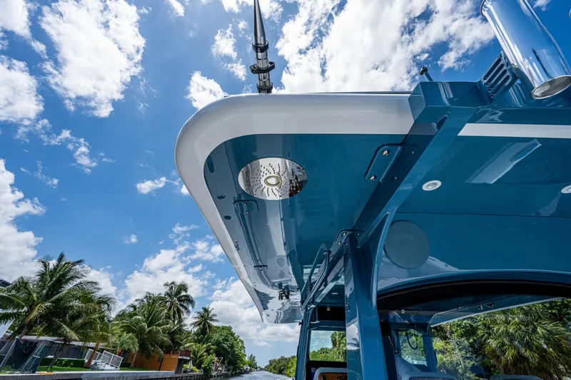 Slide: The Image of HCB 53 Sueños 2023 boat under a bright blue sky with palm trees. - 34