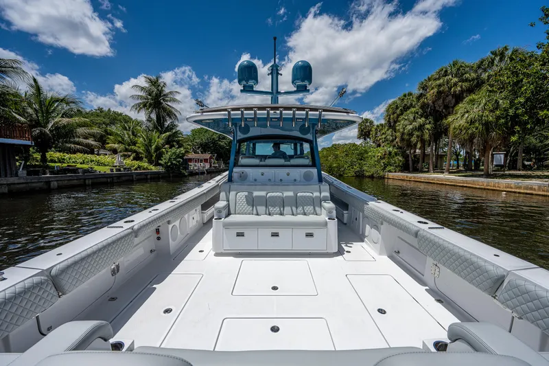 Slide: The Image of 2023 HCB 53 Sueños boat on a scenic waterway, surrounded by lush greenery and blue skies. - 7