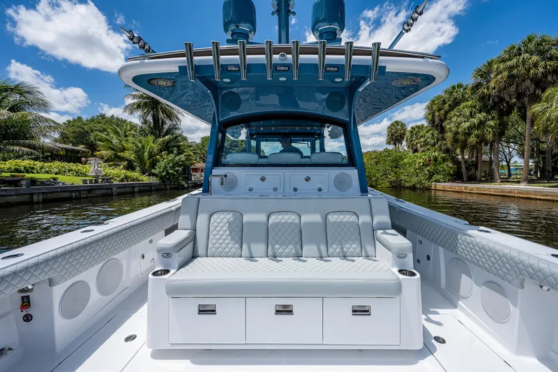 Slide: The Image of 2023 HCB 53 Sueños luxury boat interior with seating, set against a scenic waterway. - 8