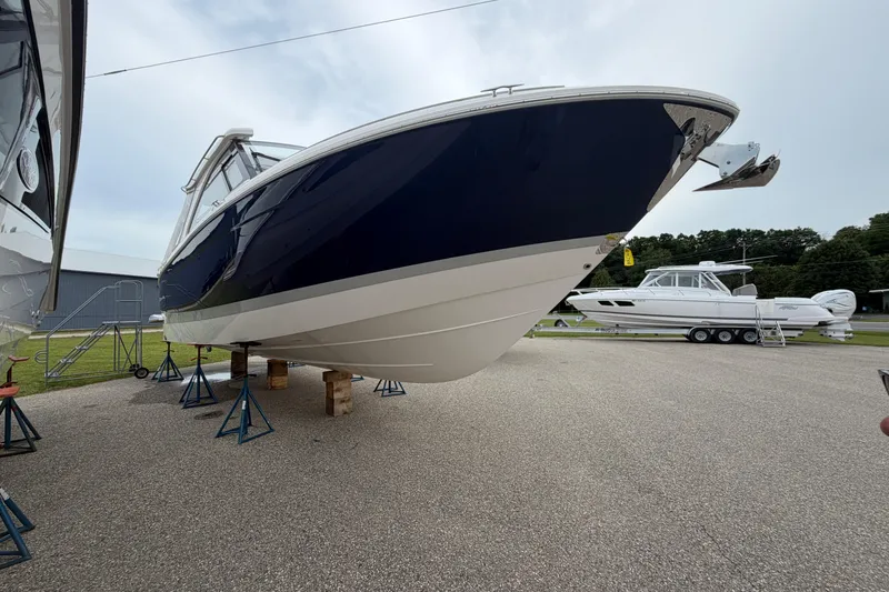 Slide: The Image of 2025 Regal LS36 boat on stands, displayed outdoors, showcasing sleek design and craftsmanship. - 1