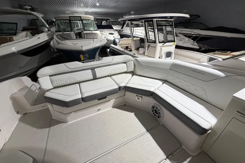 Slide: The Image of 2025 Regal LS36 boat interior with luxurious white seating in a showroom. - 23