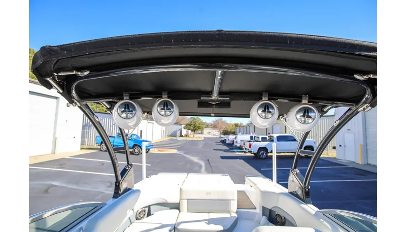 Slide: The Image of 2018 Cobalt 220S boat with speakers on a black canopy, parked outdoors. - 20