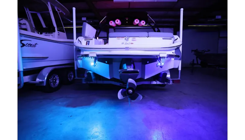 Slide: The Image of 2018 Cobalt 220S boat with blue underwater lights in a dimly lit garage. - 31
