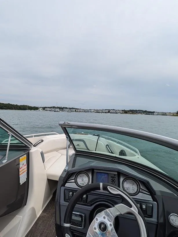 Slide: The Image of 2013 Monterey 204FS boat on calm water with scenic shoreline view. - 6