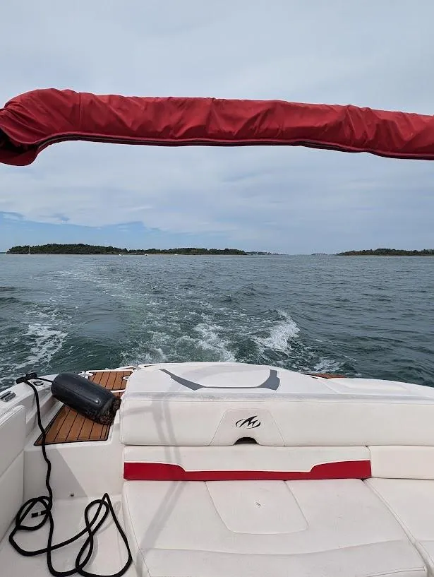 Slide: The Image of 2013 Monterey 204FS boat cruising on open water with islands in the distance. - 7