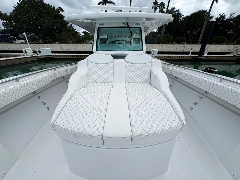 Slide: The Image of 2024 HCB 53 Sueños luxury boat with white quilted seating. - 21