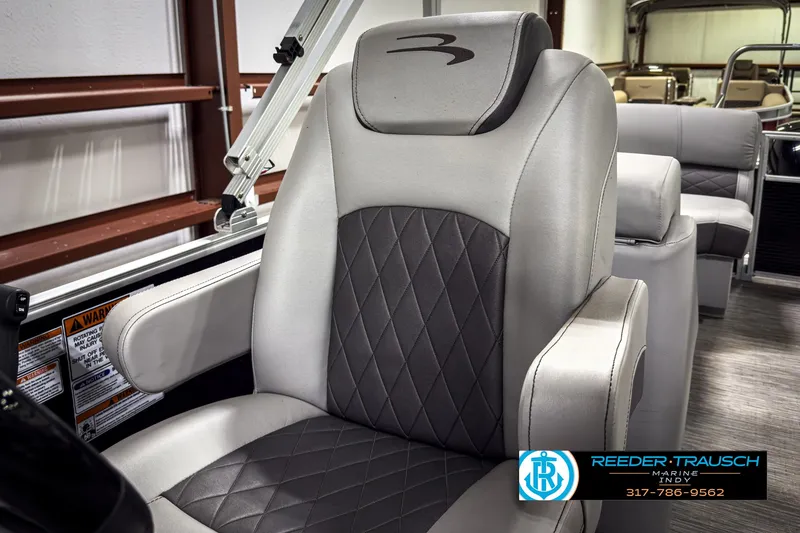 Slide: The Image of 2022 Bennington 23 LSR boat seat with diamond-pattern upholstery in a showroom. - 33