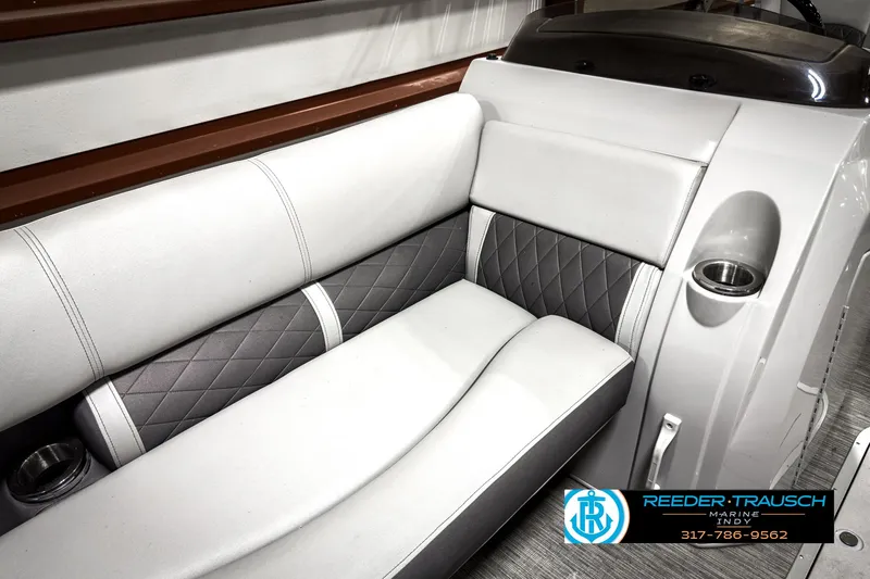 Slide: The Image of 2022 Bennington 23 LSR boat interior with gray and white seating, cup holders, and modern design. - 36