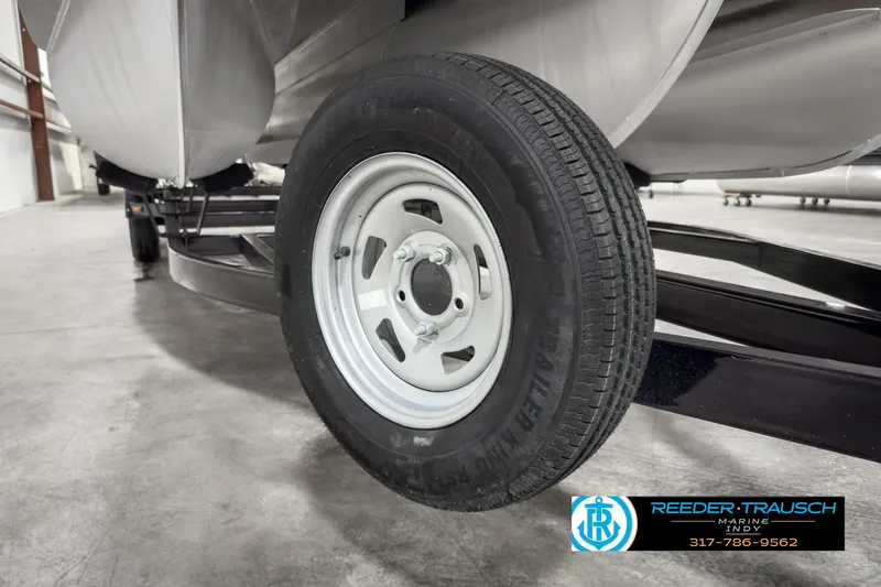 Slide: The Image of Close-up of a 2022 Bennington 23 LSR trailer wheel in a garage. - 48